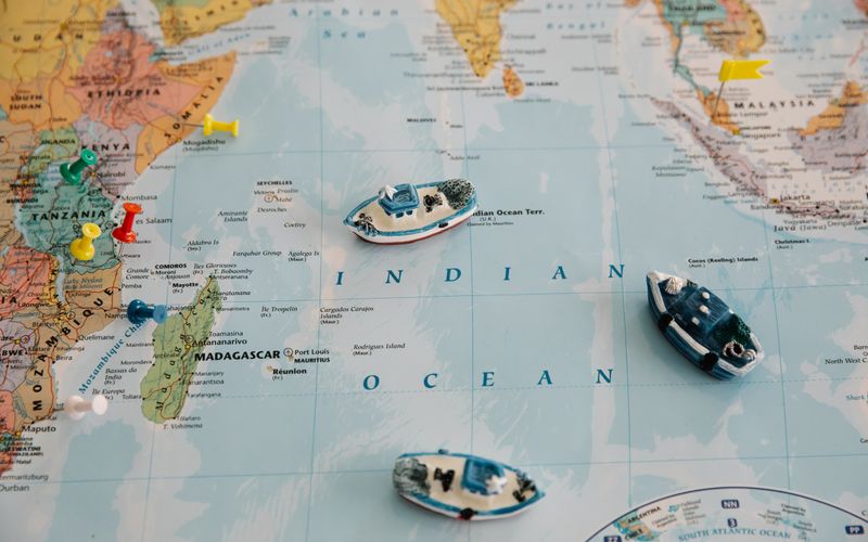 Model cargo ships and pins on a world map – countries we ship from to Australia